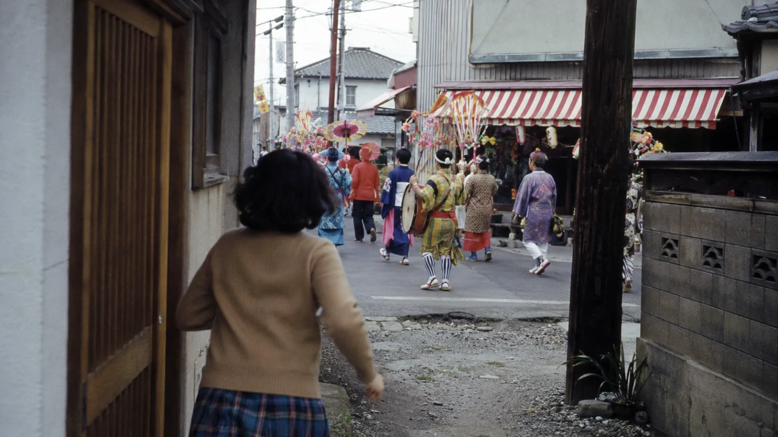 昭和40年代（1965〜1974年ごろ）の商店の開店を知らせるちんどん屋を思わせる横長の記憶風景