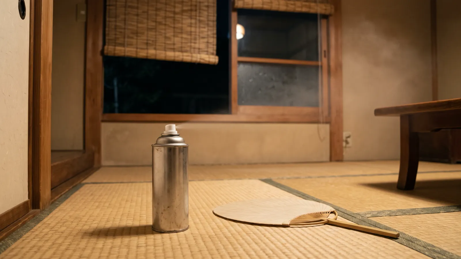 昭和27年〜昭和31年（1952〜1956年ごろ）の金鳥のキンチョールを再現したイメージ。夏の夜の畳の部屋で、すだれをかけた窓のそばに立つ無地の金属のスプレー缶と丸いうちわ。電灯の光に細かな霧が漂う。