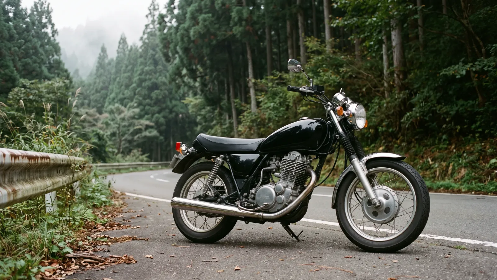 昭和53年〜昭和57年（1978〜1982年ごろ）のヤマハのSR400を再現したイメージ。杉林を背にした山道の路肩に、涙形の燃料タンクと丸いヘッドライト、冷却フィンの並ぶ単気筒エンジン、まっすぐなクロームの排気管を持つ黒いオートバイが曇り空の下で止まっている。